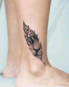 a cat's head with a feather tattoo on the ankle is shown in black and white