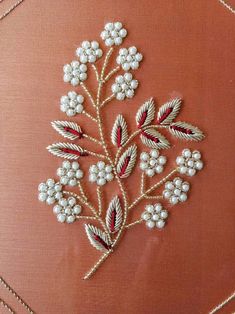 an embroidered piece with beads and flowers on it