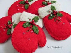 four red mittens with holly and berries on them