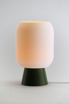 a white and green lamp sitting on top of a table