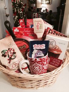 a basket filled with lots of different types of coffee and teas next to a christmas tree