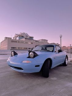 a blue sports car parked in front of a building