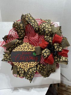 a christmas wreath with leopard print and red ribbon