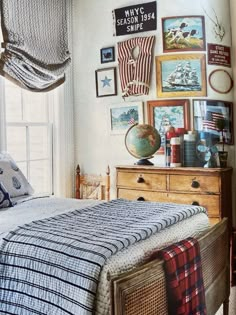 a bedroom with many pictures on the wall and a bed in front of a window