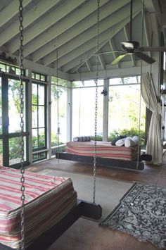 a bedroom with a swing bed in the middle and lots of windows on both sides