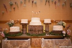 a wedding cake sitting on top of a wooden table next to flowers and greenery