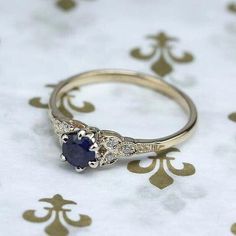 a close up of a ring on a table with a white and gold pattern background