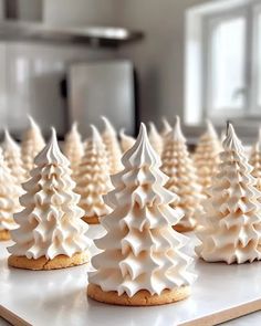 there are many cookies decorated with icing and trees on the trays in front of them