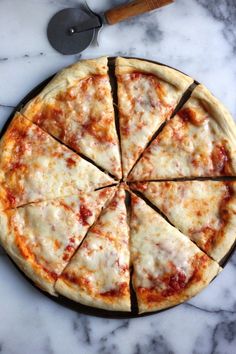 a sliced pizza sitting on top of a table next to a spatula and knife