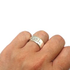 a person's hand with a silver ring on it