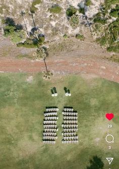 an aerial view of two rows of chairs in the middle of a field with trees