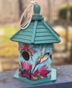 a blue birdhouse with flowers painted on it