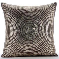 a black and white pillow with silver circles on it's side, in front of a white background