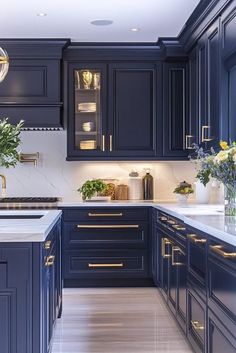 a kitchen with blue cabinets and white counter tops, gold trimmings on the doors