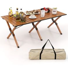 a picnic table with food and drinks on it next to a duffel bag filled with bottles