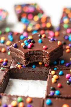 there are many pieces of chocolate cake with candy on the top one is cut in half