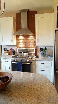 a kitchen with an oven, stove and sink in it's center island next to a refrigerator