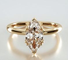 a yellow gold ring with a pear shaped diamond