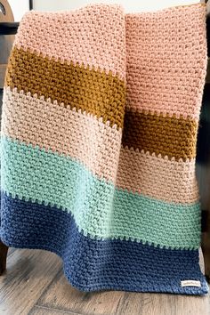 a crocheted blanket sitting on top of a wooden chair