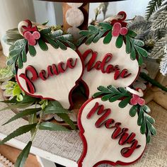 three wooden christmas decorations with the words peace, love, and merry written on them