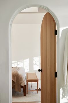 an open door leading to a bedroom with white walls