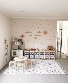 a playroom with sunflowers on the wall and storage bins for children's toys