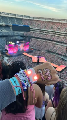 a person holding up their wrist with the number 35 on it in front of an arena