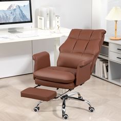 an office chair and footstool in front of a desk with a computer on it