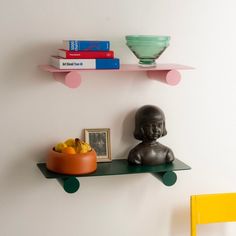 there is a shelf with books and bowls on it