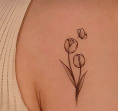 a woman's back shoulder with three tulips on it