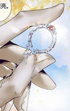 a hand holding a chain with a ring hanging from it's middle finger, in front of a blue sky and clouds