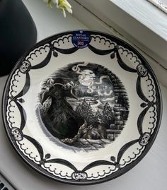 a black and white plate sitting on top of a window sill