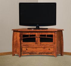 a flat screen tv sitting on top of a wooden entertainment center table in a living room