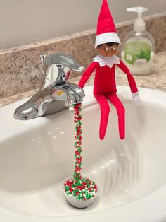 an elf is sitting in the bathroom sink with his feet on the faucet