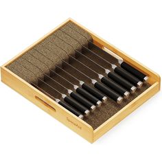 a wooden box filled with lots of black pens