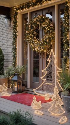 christmas lights decorate the front porch of a house with wreaths and trees on it