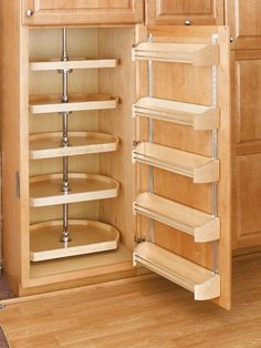 an open cabinet in a kitchen with wooden floors and cabinets on both sides, including pull out shelves