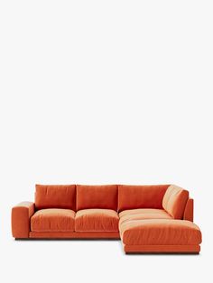 an orange sectional couch sitting on top of a white floor