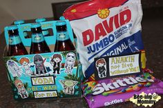 two bottles of soda, some candy and a bag on a table with other items