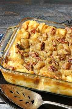 a casserole dish with pecans in it on a plate next to a spoon