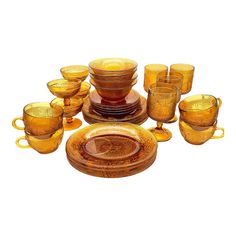 a collection of yellow glass dishes and cups with matching saucers, bowls and plates