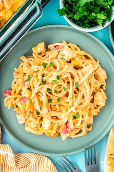 a plate of pasta with chicken and parsley on it next to two bowls of vegetables