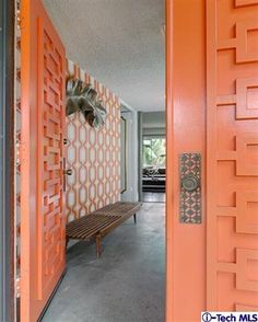 an orange door and bench in a room