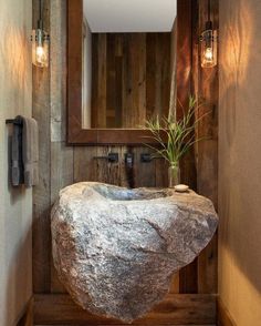 a bathroom with a rock sink and mirror