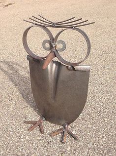 an owl statue sitting on top of a cement ground