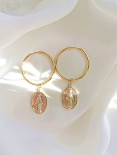 *22 karat gold plated hoop earrings for pierced ears *Charms: beautiful and very detailed Mother Mary medallions *Rings size: 20 mm *Ring thickness: 2  mm *Earrings length: 6 cm *Luxurious logo packing included Gold-plated Gold Hoop Earrings As A Gift, Gold Round Huggie Earrings In 14k Gold Filled, 14k Gold Filled Hoop Charms Jewelry, Gift Single Hoop Earring, Rose Gold Plated Huggie Earrings As Gift, Gold Tarnish Resistant Hoop Earrings As Gift, Tarnish Resistant Gold Hoop Earrings For Gift, Small Hoop Brass Jewelry With Charms, Brass Small Hoop Jewelry With Charms