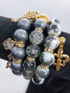 Add a touch of style to any outfit with this beautiful stack of beaded bracelets handcrafted with various glass and metal beads. The mix of beautiful grays and gold will accentuate your favorite outfit.  Sold as a set of 3 bracelets. Will fit 7 to 7.5 inch wrist. Gold Bracelet Stack, Wire Wrap Bracelets, Cat Charm Bracelet, Diy Beaded Jewelry, Bracelet Business, Gold Bracelets Stacked, Supplements Packaging, Memory Wire Wrap Bracelets, Vintage Jewelry Ideas