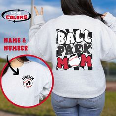 Our customizable Ballpark Mom sweatshirt features a groovy, retro vibe. The back of this super comfy baseball sweater boasts groovy text set against a trendy checkerboard background. Customize the front pocket area with your player's name and jersey number.  ** SWEATSHIRT FEATURES ** This unisex heavy blend crewneck sweatshirt is made from polyester and cotton and is created for comfort. .: Medium-heavy fabric (8.0 oz/yd² (271.25 g/m .: Loose fit .: Runs true to size .: 50% cotton, 50% polyester Sporty Graphic Print Sweatshirt For Baseball Season, Relaxed Fit Graphic Print Sweatshirt For Baseball Season, Game Day Baseball Season Graphic Sweatshirt, Baseball Season Game Day Graphic Sweatshirt, Graphic Print Sweatshirt For Baseball Game Day, Athletic Heather Sweatshirt With Graphic Print For Sports Events, Baseball Season Sports Fan Sweatshirt With Graphic Print, Baseball Season Graphic Print Sports Fan Sweatshirt, Sports Fan Baseball Sweatshirt With Graphic Print