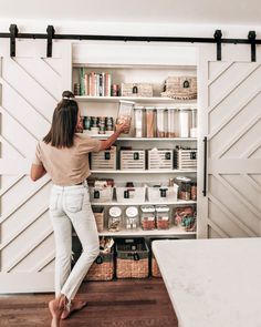 a woman standing in front of a pantry filled with food