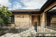 a brick house with wrought iron railings and stairs